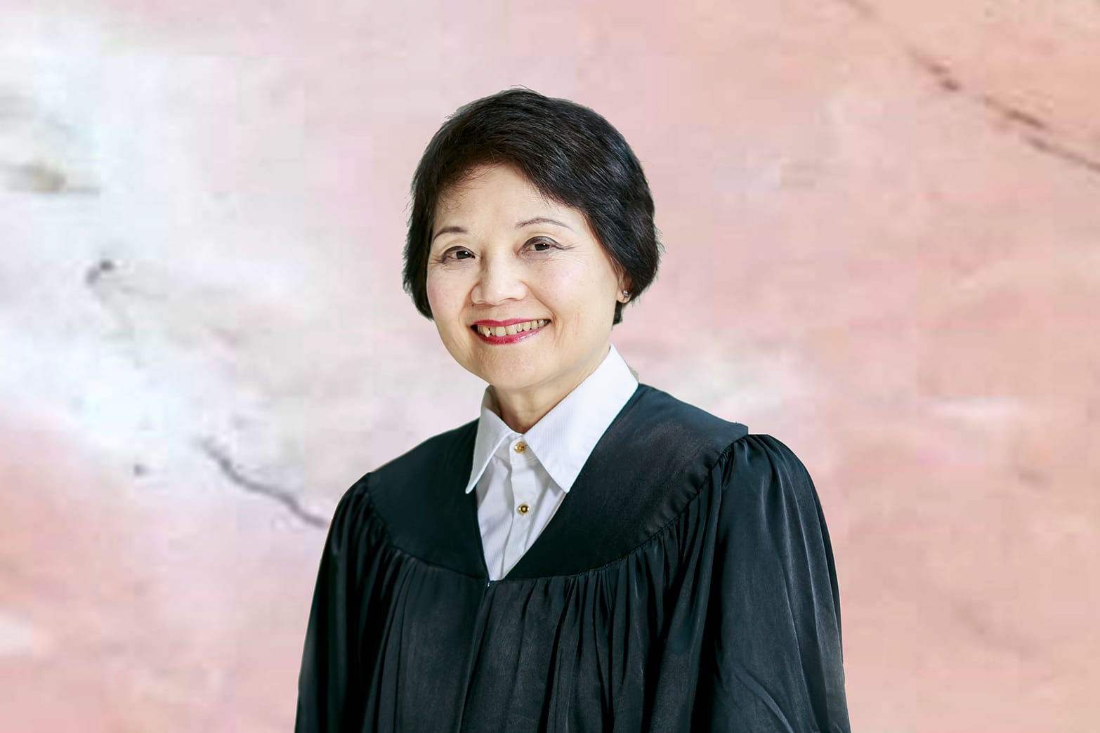 Portrait of a woman wearing a black judicial robe and a white collared shirt.